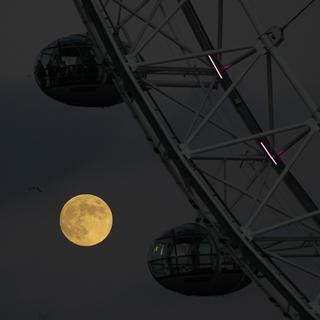 Mercredi 7 décembre: la dernière pleine Lune de l'année se lève sur Londres et la roue du London Eye. [Keystone/AP Photo - Alastair Grant]