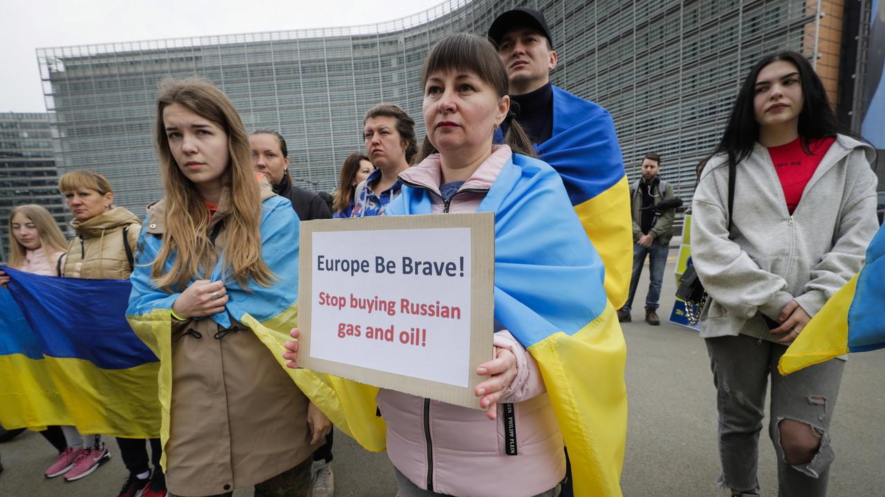 Des Ukrainiens manifestent devant les institutions européennes à Bruxelles pour demander de nouvelles sanctions. [Keystone/EPA - Olivier Hoslet]