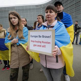 Des Ukrainiens manifestent devant les institutions européennes à Bruxelles pour demander de nouvelles sanctions. [Keystone/EPA - Olivier Hoslet]