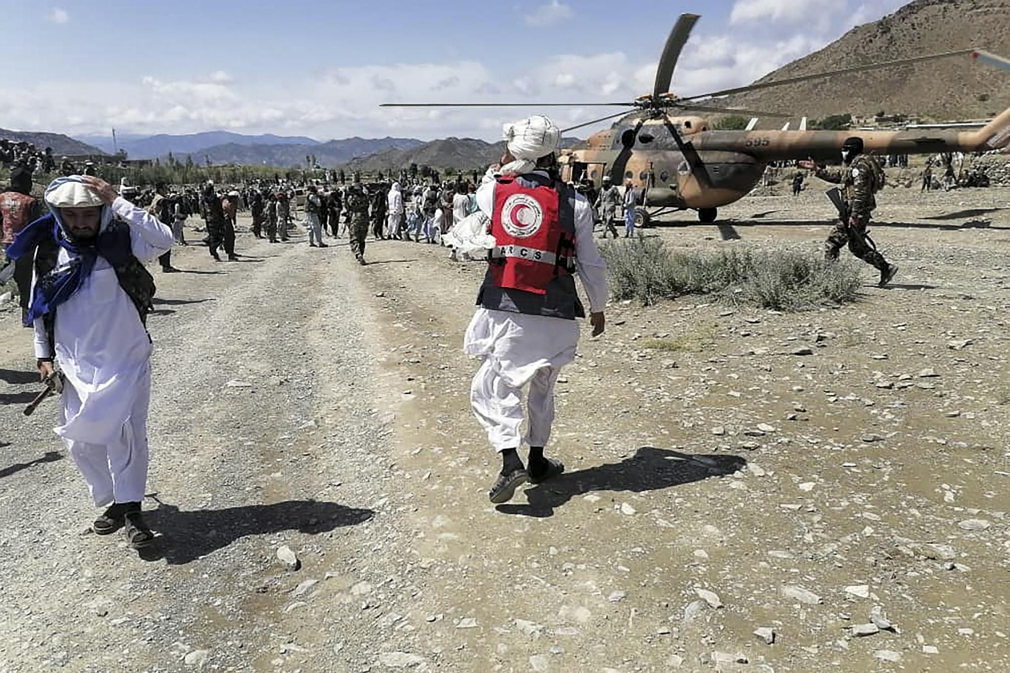 Des soldats et des membres du Croissant-Rouge afghan s'activent près d'un hélicoptère dans une zone touchée par le séisme dans le district de Giyan, dans la province de Paktika. [AFP - Bakhtar News Agency]