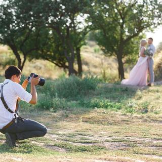 Un photographe prend en photo un couple le jour d eleur mariage. [Depositphotos - erstudio]