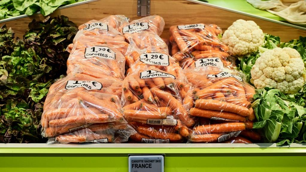 Des carottes à bas prix emballées dans du plastique dans un rayon frais de fruits et légumes d'un supermarché Super U en France. [AFP - Mathieu Thomasset / Hans Lucas]