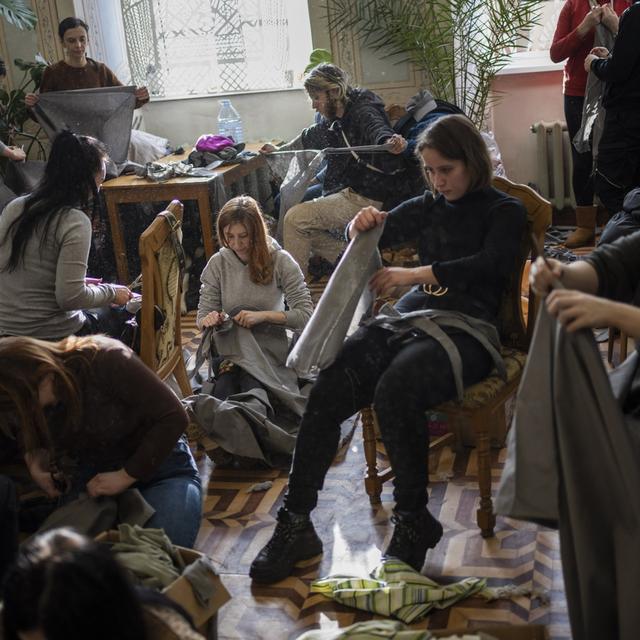 Volontaires affairés à la fabrication de filets de camouflage à Lviv, 28.02.2022. [AP/Keystone - Bernat Armangue]