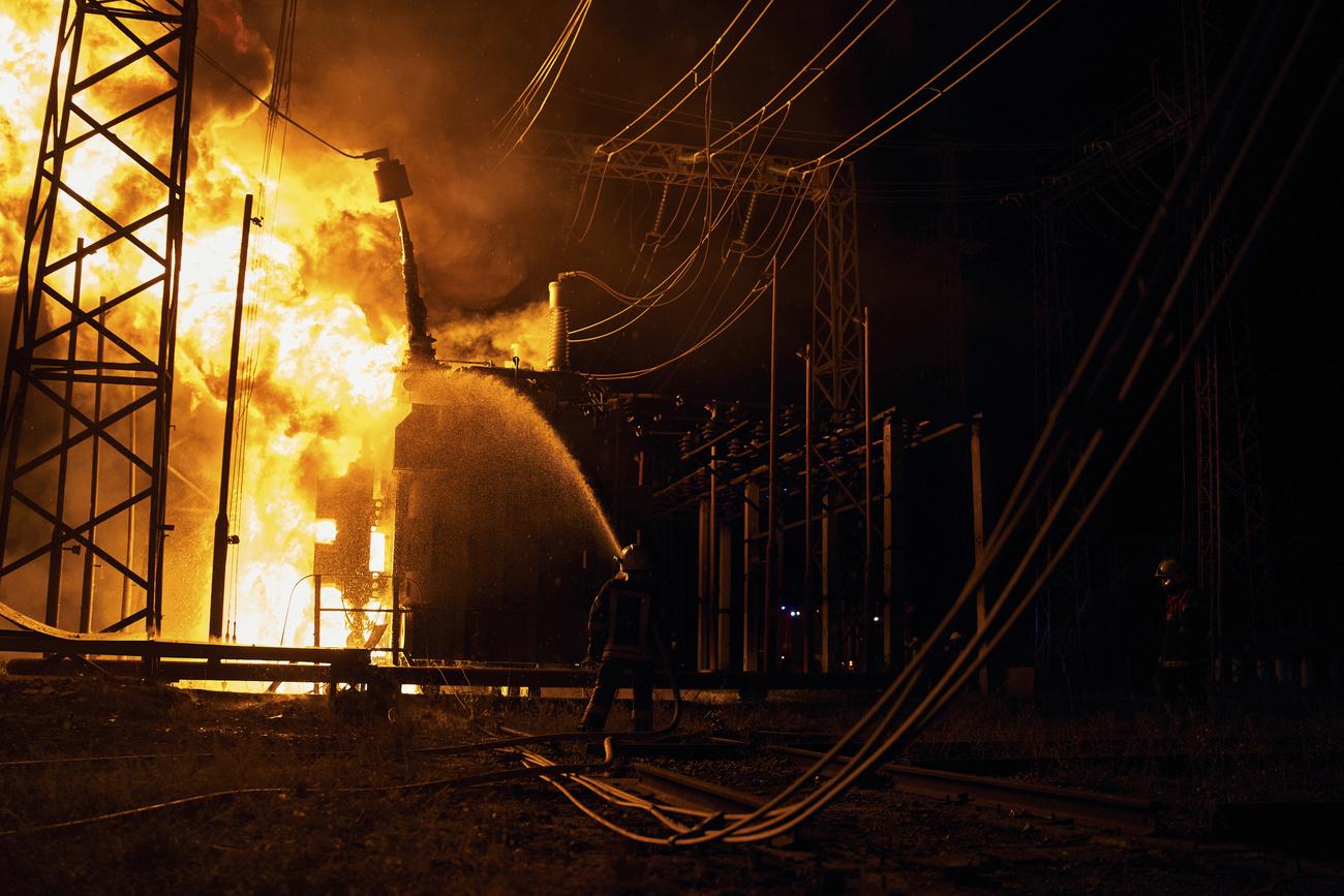 Des pompiers en action après qu'une roquette russe a touché une centrale électrique à Kharkiv, nord-est de l'Ukraine, le dimanche 11 septembre 2022. [Keystone - AP Photo/Kostiantyn Liberov]