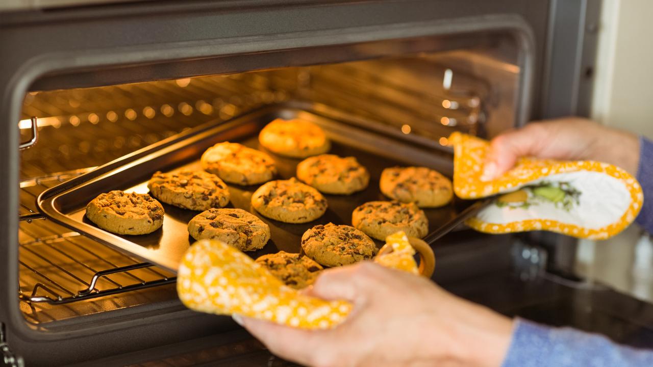 Un homme met des cookies à cuire au four. [Depositphotos - Wavebreakmedia]