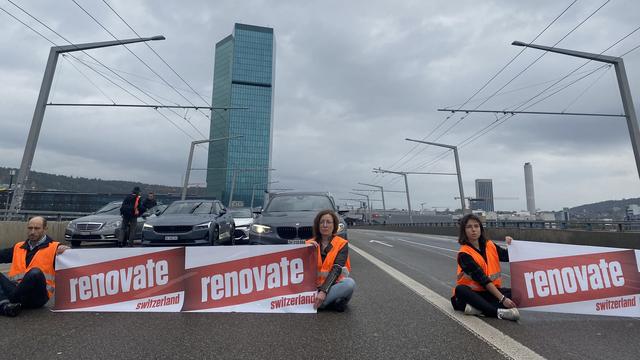 Six militants et militantes bloquent un pont à Zurich. [@Renovate_CH]