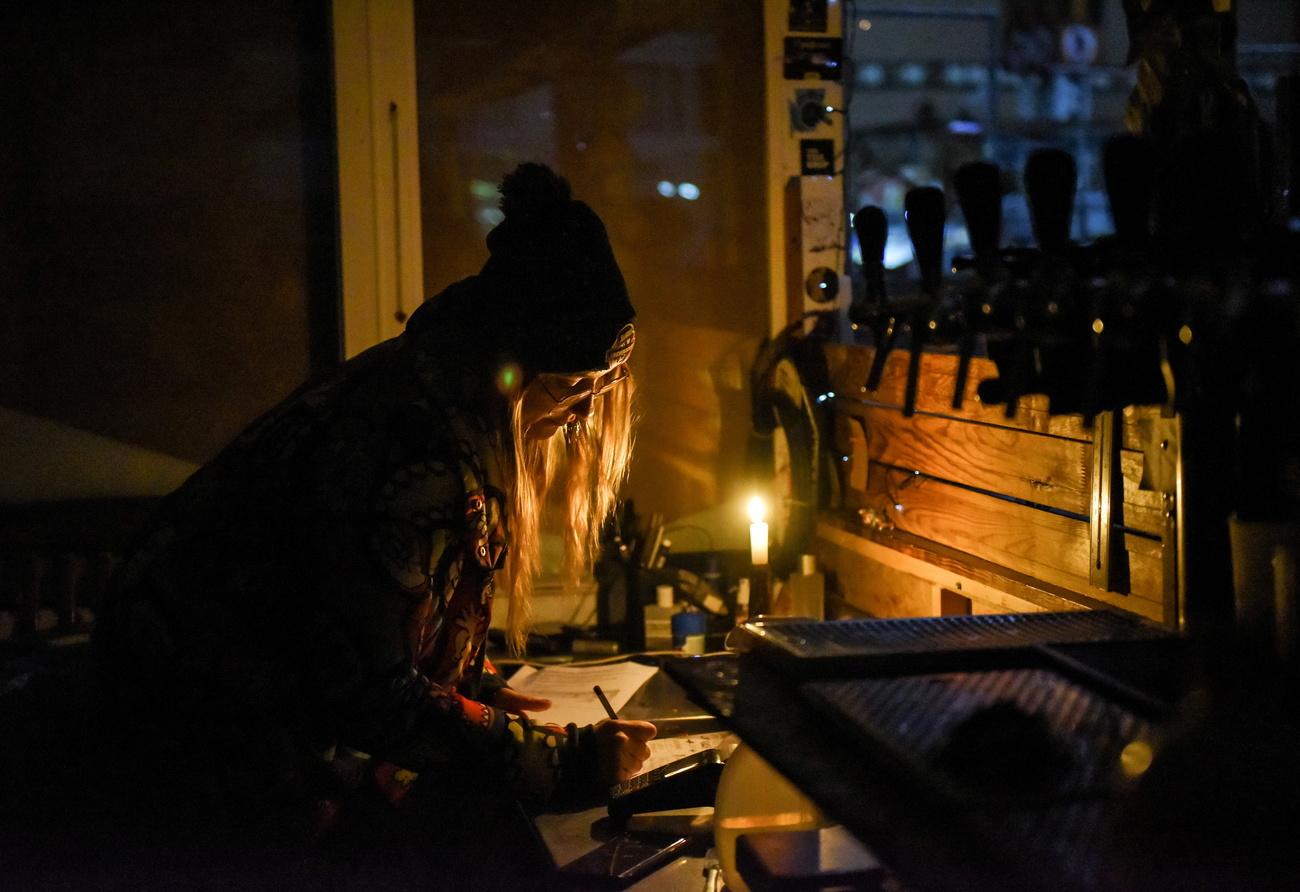 Une commerçante ukrainienne travaille dans la nuit à Kiev. [Keystone - EPA/Oleg Petrasyuk]