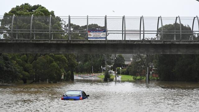 Une voiture est inondée dans les eaux de crue à Lansvale, dans l'ouest de Sydney, en Australie. [KEYSTONE - Mick Tsikas / EPA]