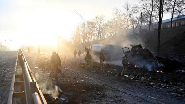 Des soldats ukrainiens dans les décombres après un affrontement face à des troupes russes proche de Kiev. [AFP - Sergei Supinsky]