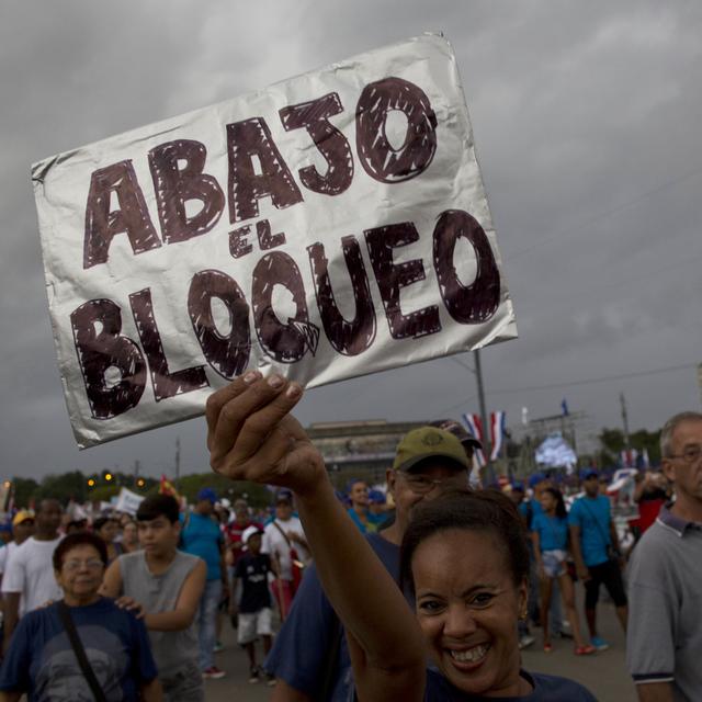 Une femme brandit une pancarte écrite à la main contre l'embargo américain lors d'une marche sur la place de la Révolution marquant le 1er mai, à La Havane, Cuba, vendredi 1er mai 2015. [AP Photo/KEYSTONE - Ramon Espinosa]