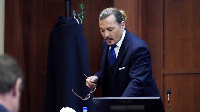 L'acteur américain Johnny Depp se rend à la barre du tribunal de Fairfax lors de son procès contre son ex-femme, l'actrice Amber Heard, le 25 avril 2022. [Keystone - Steve Helber]