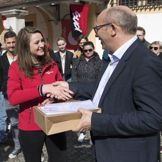 Lea Ziegler remet des signatures au vice-chancelier de l'Etat de Neuchatel Pascal Fontana. [Keystone - Laurent Gillieron]