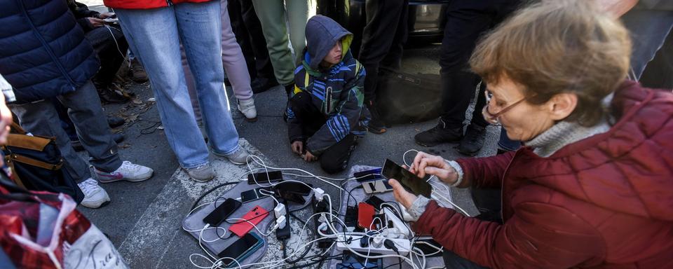 Des habitants de Kherson viennent charger leur téléphone à un générateur. [EPA - Oleg Petrasyuk]