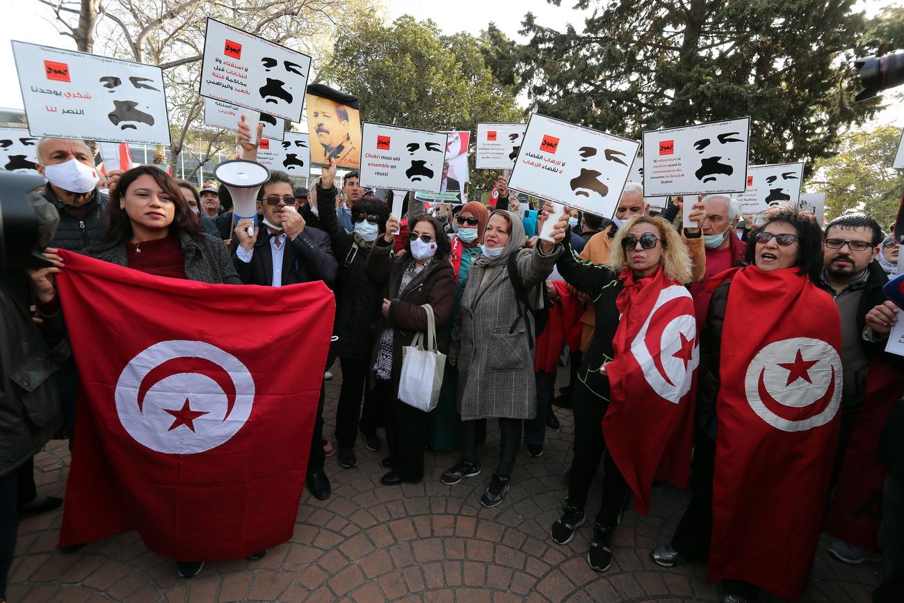 Des Tunisiens et Tunisiennes scandent des slogans lors d'une manifestation à Tunis le 6 février 2022 pour commémorer le 9e anniversaire de l'assassinat du leader de l'opposition de gauche Chokri Belaïd. [KEYSTONE - Mohamed Messara / EPA]