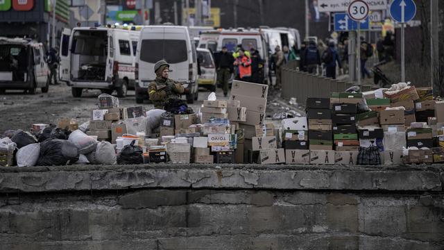 Un soldat ukrainien près de carton d'aide humanitaire, dans le village d'Irpin dans la banlieue de Kiev, le 9 mars 2022. [AP/Keystone - Vadim Ghirda]