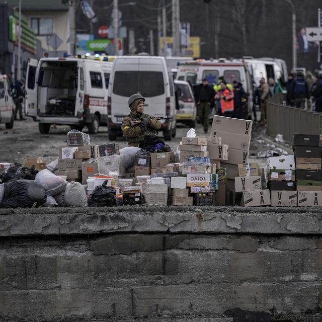 Un soldat ukrainien près de carton d'aide humanitaire, dans le village d'Irpin dans la banlieue de Kiev, le 9 mars 2022. [AP/Keystone - Vadim Ghirda]