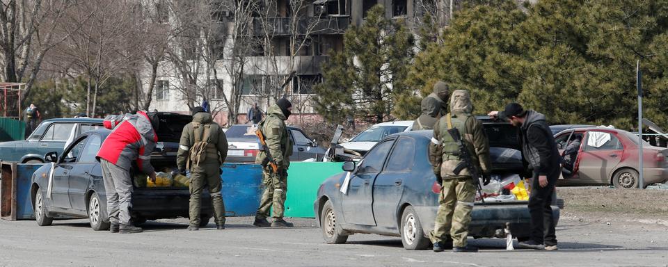 Des soldats prorusses contrôlent des voitures à Marioupol. [Reuters - Alexander Ermochenko]