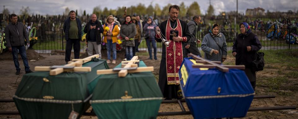 Cérémonie funèbre pour l'enterrement de victimes à Boutcha, le 27.04.2022. [AP/Keystone - Emilio Morenatti]