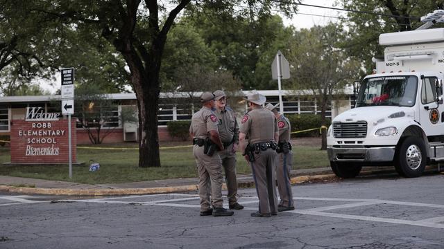 Des policiers devant l'école où a eu lieu une tuerie de masse à Uvalde, au Texas. [Keystone/EPA - Aaron M. Sprecher]