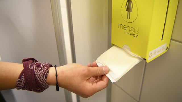 Une jeune fille d'une classe de 9e année secondaire utilise une serviette hygiénique gratuite provenant d'un distributeur dans les toilettes de l'école. [KEYSTONE - Laurent Gillieron]