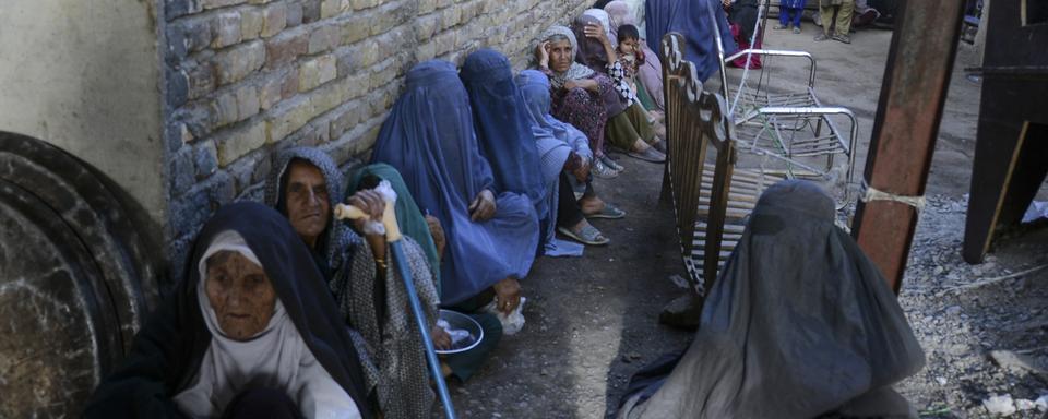 Des femmes attendent de recevoir de la nourriture à Kandahar. [Keystone - Javed Tanveer]