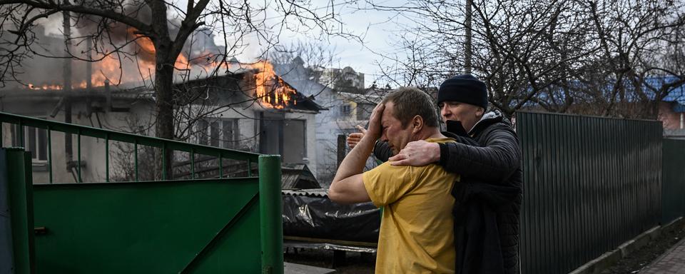 4 mars 2022, Irpin, près de Kiev: un propriétaire devant sa maison en feu après avoir été touchée par un obus. [AFP - Aris Messinis]