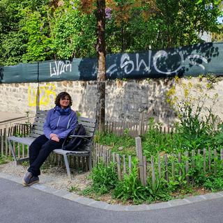 Myriam Charollais, conseillère en projets «nature en ville» au service des parcs et domaines de la ville de Lausanne assise devant un jardin de poche du quartier de Beaulieu. [RTS - X. Bloch]
