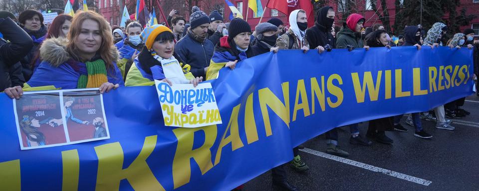 Des Ukrainiens et Ukrainiennes manifestent dans la rue contre l'attitude menaçante de la Russie à l'égard de leur pays. [AP/Keystone - Efrem Lukatsky]