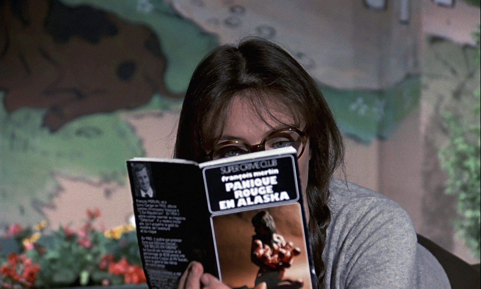 Christine (Jacqueline Bisset) lit un roman de François Merlin (Jean-Paul Belmondo) dans le film "Le Magnifique". [Collection ChristopheL via AFP]