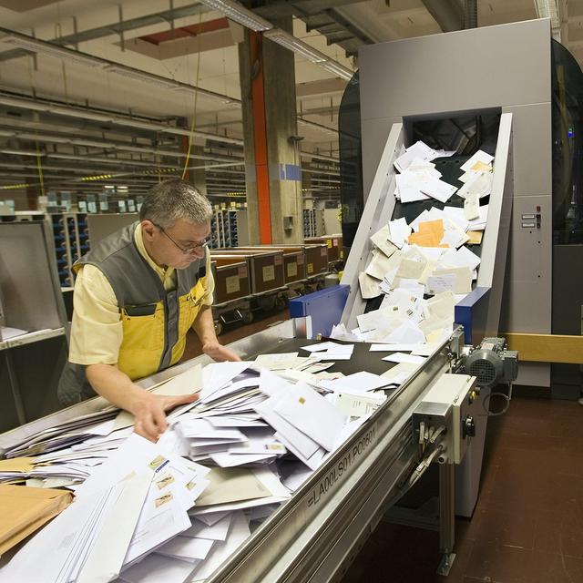 Un employé travaille sur l'unité de séparation du courrier CFC au centre logistique de traitement du courrier de Genève, mardi 20 janvier 2009. [KEYSTONE - Salvatore Di Nolfi]