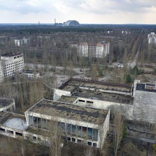 La zone d'exclusion de Tchernobyl avec au loin le sarcophage entourant la centrale accidentée. [Keystone - AP Photo/Efrem Lukatsky]