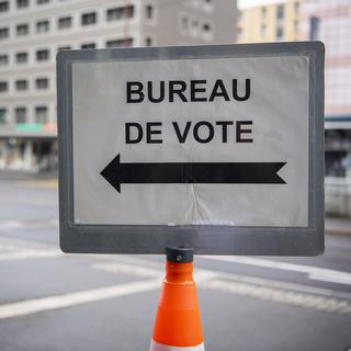 Un panneau indiquant l'entrée d'un bureau de vote. [Keystone - Jean-Christophe Bott]