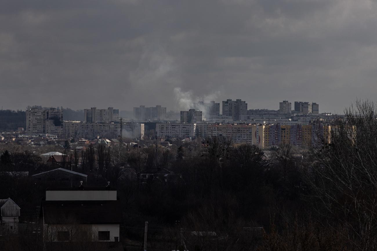 De la fumée s'élève d'un quartier résidentiel de Kharkiv, soumise à des bombardements répétés. [Keystone/EPA - Roman Pilipey]