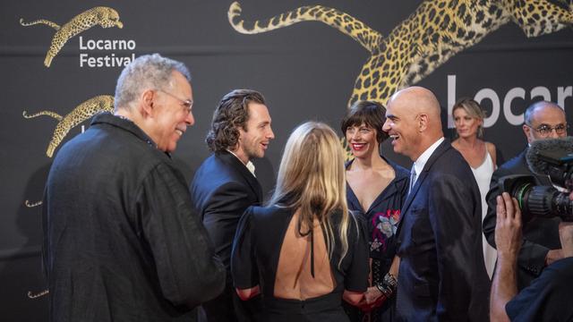 Le conseiller fédéral Alain Berset salue l'acteur britannique Aaron Taylor-Johnson mercredi 3 août lors du 75e Festival de Locarno. [Keystone - Urs Flueeler]