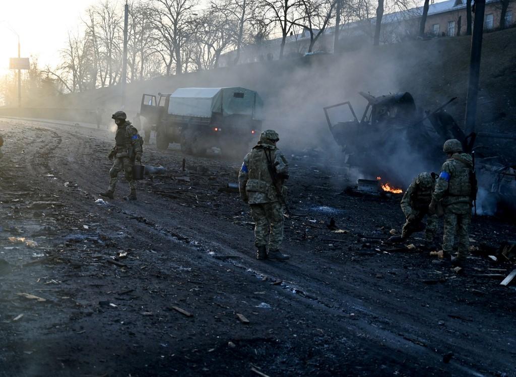 Des membres de l'armée ukrainienne collectent des munitions intactes après un bombardement à Kiev. [AFP - Sergei Supinsky]