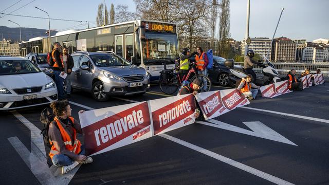 Les activistes ont tiré une banderole en travers du pont du Mont-Blanc à Genève. [Keystone - Martial Trezzini]