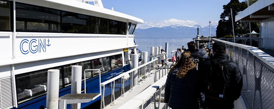 Des personnes embarquent dans le bateau de la CGN pour naviguer sur le lac Léman. [Keystone - Jean-Christophe Bott]