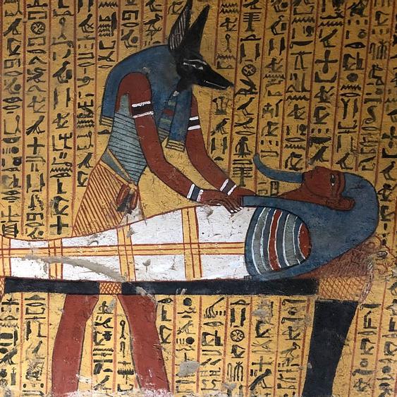 Représentation datant du règne de Ramsès II (1279-1213 avant J.-C.) du dieu Anubis s'occupant de la momie d'un ouvrier. Provenance: nécropole de Deir el-Medina à Thèbes, Égypte. Anubis est un dieu funéraire de l'Égypte antique, maître des nécropoles et protecteur des embaumeurs, représenté comme un grand canidé noir couché sur le ventre, sans doute un chacal ou un chien sauvage, ou comme un homme à tête de canidé.