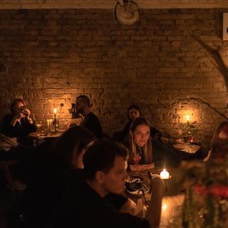 Clients d'un restaurant de Kiev éclairés à la bougie. [EPA/Keystone - Roman Pilipey]