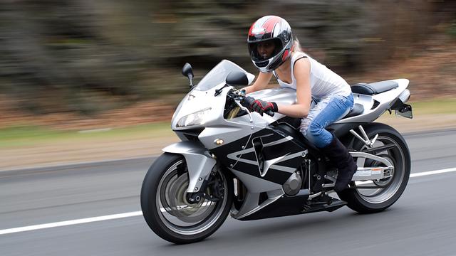 Une jeune motarde prend de la vitesse. [Depositphotos - ArenaCreative]