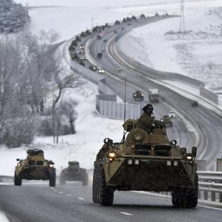 Un convoi de véhicules blindés russes se déplace sur une autoroute en Crimée le 18 janvier 2022. La Russie a concentré environ 100'000 soldats près de l'Ukraine. [Keystone - AP Photo]