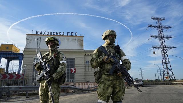 Des troupes russes gardent l'entrée de la centrale hydroélectrique de Kakhovka, une centrale au fil de l'eau sur le fleuve Dniepr dans la région de Kherson, dans le sud de l'Ukraine, vendredi 20 mai 2022. [AP Photo/KEYSTONE]