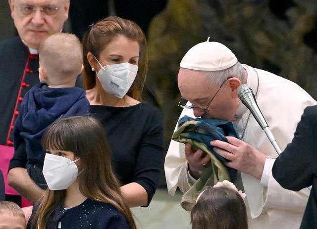 Le pape François embrasse un drapeau ukrainien qui provient de la ville de Boutcha. [Keystone/EPA - Ettore Ferrari]