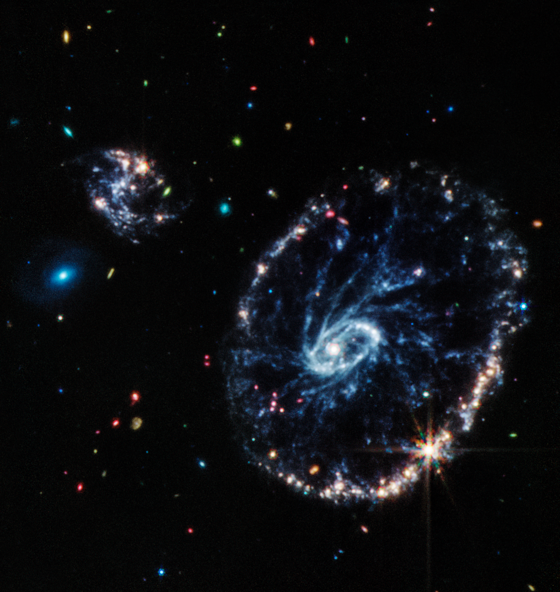 Cette image de l'instrument MIRI (Mid-Infrared Instrument) du JWST montre un groupe de galaxies, dont une grande galaxie en forme d'anneau déformé connue sous le nom de Roue de chariot, ou Cartwheel en anglais. [NASA, ESA, CSA, STScI - MIRI/Webb ERO Production Team]