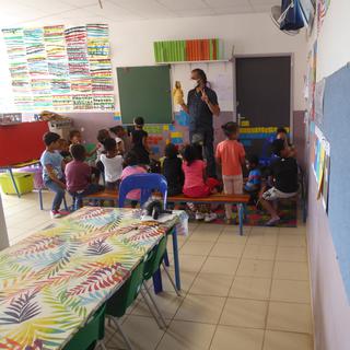 Guillaume Aribaud avec ses élèves de cinq ans à l’école primaire Zac Faillard de Saint-André. Pour pallier l’absence de supports pédagogiques en créole, l’enseignant se sert de… marionnettes ! [Margot Hemmerich]