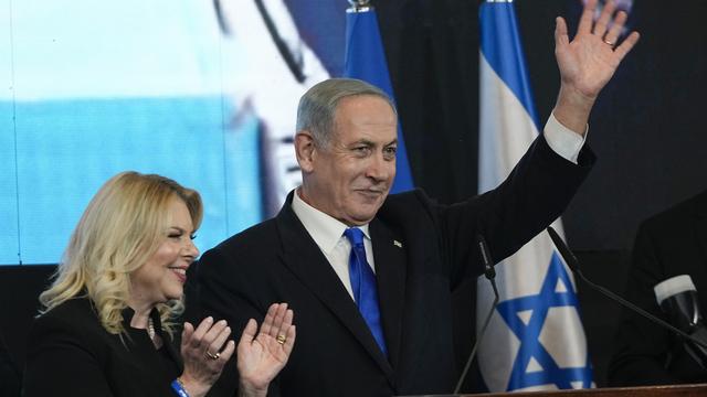 Benjamin Netanyahu, accompagné de sa femme, salue ses partisans après les résultats du premier sondage à la sortie des élections parlementaires israéliennes, le 2 novembre 2022 [Keystone - EPA/ABIR SULTAN]