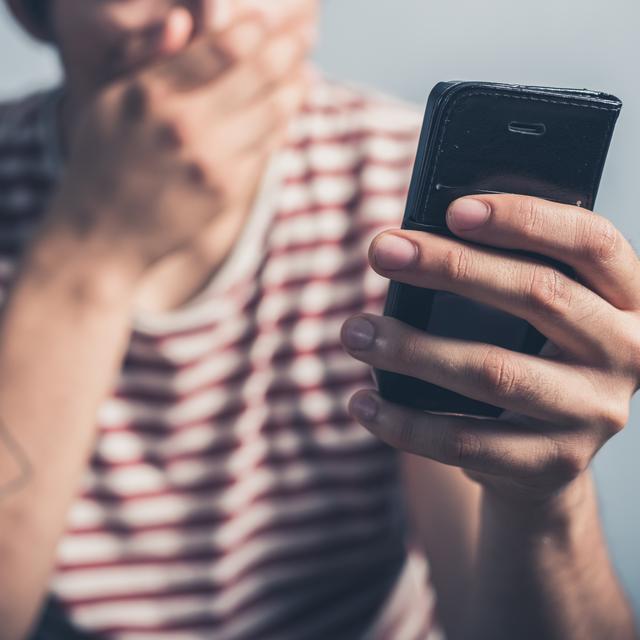 Un homme choqué devant son smartphone. [Depositphotos - lofilolo]