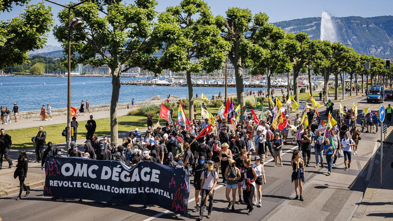 Des personnes défilent à Genève lors d'une manifestation contre l'Organisation mondiale du commerce (OMC) à la veille de sa 12e Conférence ministérielle. [KEYSTONE - Valentin Flauraud]