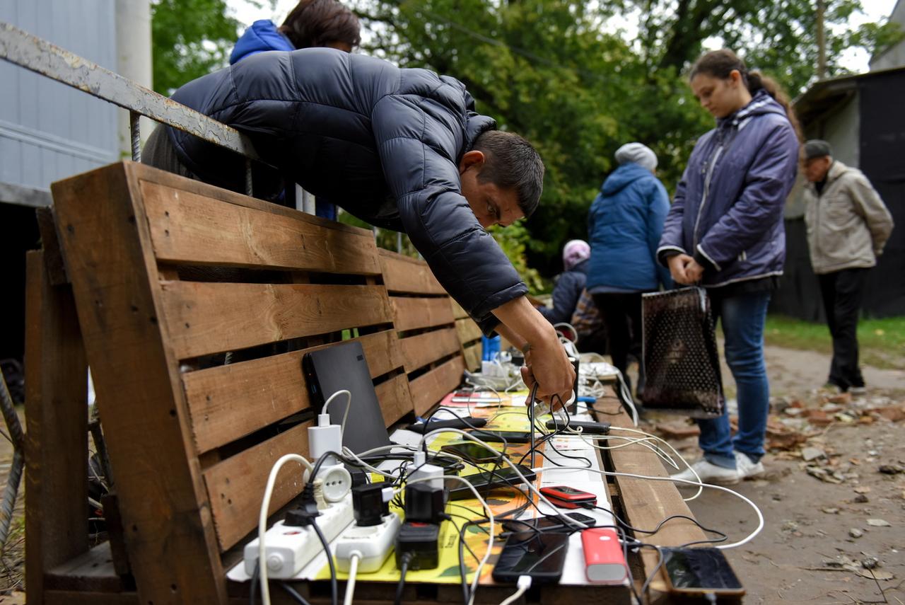 Pour recharger leurs téléphones et pouvoir continuer à communiquer avec le monde extérieur, les Ukrainiens et Ukrainiennes se débrouillent, comme ici dans la région de Kharkiv. [Keystone - Oleg Petrasyuk]