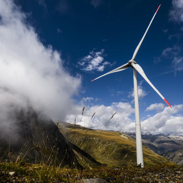 Une eolienne sur les montagnes tourne grace au vent pres du barrage de Gries le vendredi 2 septembre 2022 vers le col du Nufenen en Valais. [Keystone - Jean-Christophe Bott]